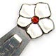 This bookmark was made in Norway. It is marked 830S with an H hallmark. The top is a figural flower with white enamel petals and a red enamel center. The front is inscribed "Tine". The date is 1920 - 1930.