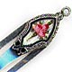 This bookmark was made in the US by an unknown manufacturer. It is marked with the makers mark and sterling. The top is an enamel picture of pink flowers The date is 1900 - 1910.