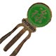 This bookmark was made in China. It is made of tin and enamel paint and is green with a Chinese symbol on the top. Written underneath the symbol is "Prosperity". The date is 1970 - 1980.  