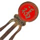 This bookmark was made in China. It is made of tin and enamel paint and is red with a Chinese symbol on the top. Written underneath the symbol is "Good Luck". The date is 1970 - 1980.  
