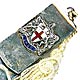 This bookmark is made in Birmingham, England. It is marked with the the date mark of 1959 and the hallmarks for Birmingham. It is silver and enamel and has a shield of a cross flanked by two griffins. A cream colored tassel is attached to the top.  