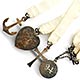 This bookmark was made in the US by an unknown manufacturer. It is marked only sterling. It is a bible bookmark with 4 charms, three at the end of silk ribbons and one on top. The heart charm says "We praise thee oh God." The date is 1894.