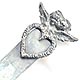 This bookmark was made in the US by an unknown manufacturer. It is marked only sterling. It depicts two cherub heads, a girl and a boy where the boy is kissing the girl. The heads are above two wings. The top blade is a cut out heart shape. The date is 1900 - 1910.