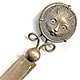  This bookmark was made in France. It is brass and the top is a relief picture of a kitty with light green glass eyes. The date is 1890 - 1910.  